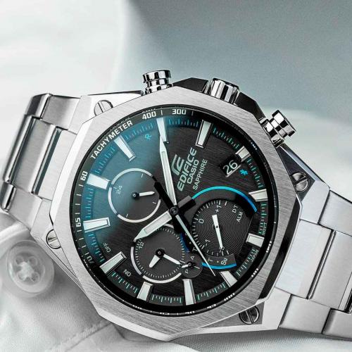Текстурированный антрацитовый циферблат тонких часов CASIO EDIFICE EQB-1100D-1AER дополнен яркими бирюзовыми акцентами.