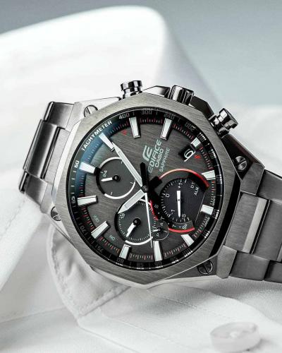 Текстурированный антрацитовый циферблат тонких часов CASIO EDIFICE EQB-1100DC-1AER дополнен яркими красными акцентами.