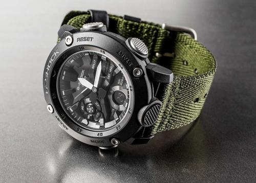 Черные карбоновые часы CASIO G-SHOCK GA-2000E-4ER на зеленом тканевом ремешке, студийное фото.