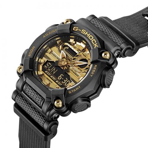 Большой 10-гранный корпус часов CASIO G-SHOCK GA-900AG-1AER украшен четырьмя позолоченными gold винтами.