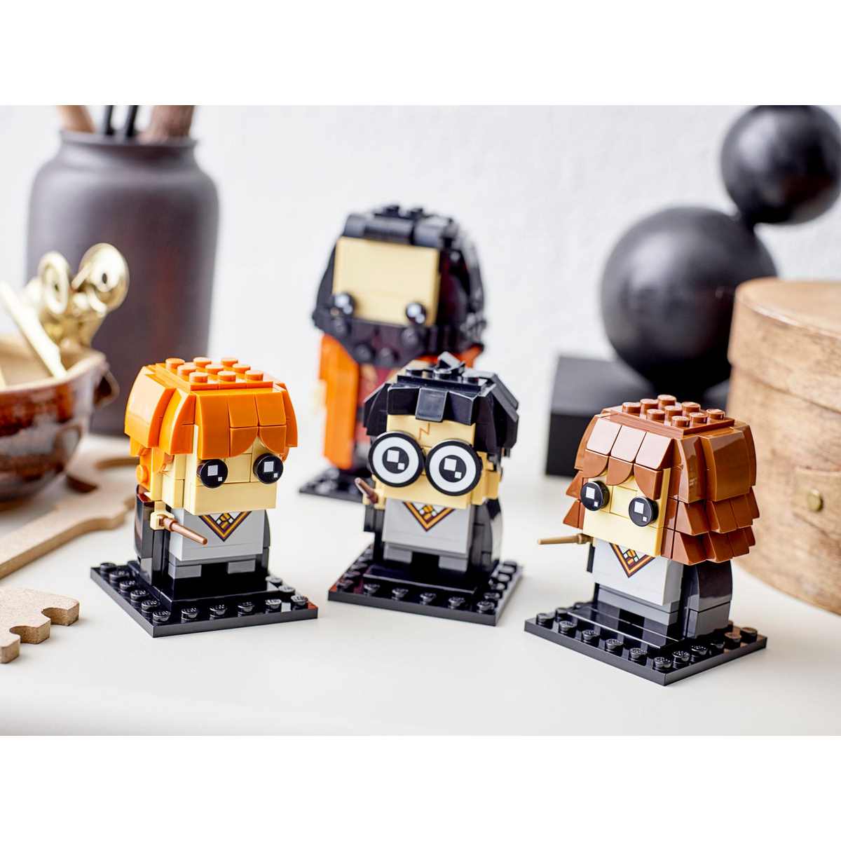 Персонажи студентов Хогвартса набора LEGO® BrickHeadz™ Harry Potter™ (40495) одеты в черные мантии, ниспадающие на землю.
